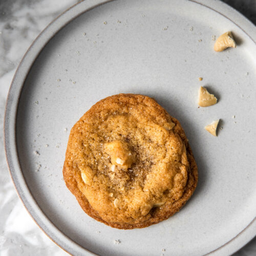 a single serving white chocolate chip cashew cookie on a plate.
