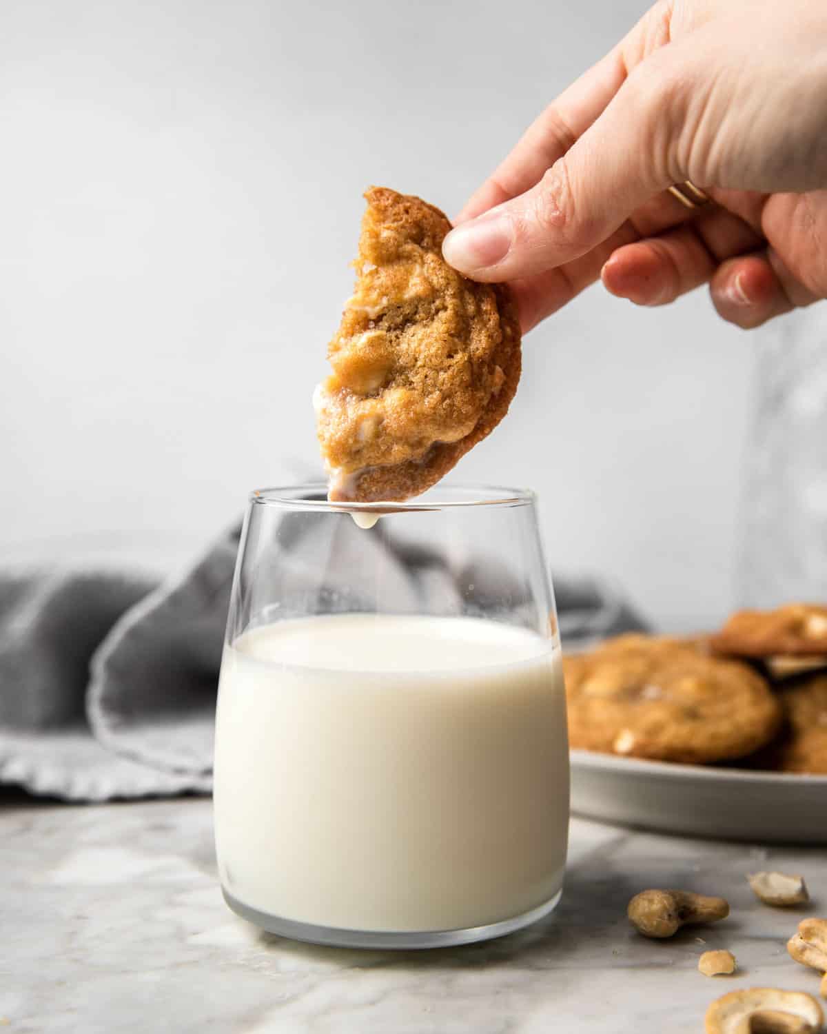 dunking half a cookie in a glass filled with milk.