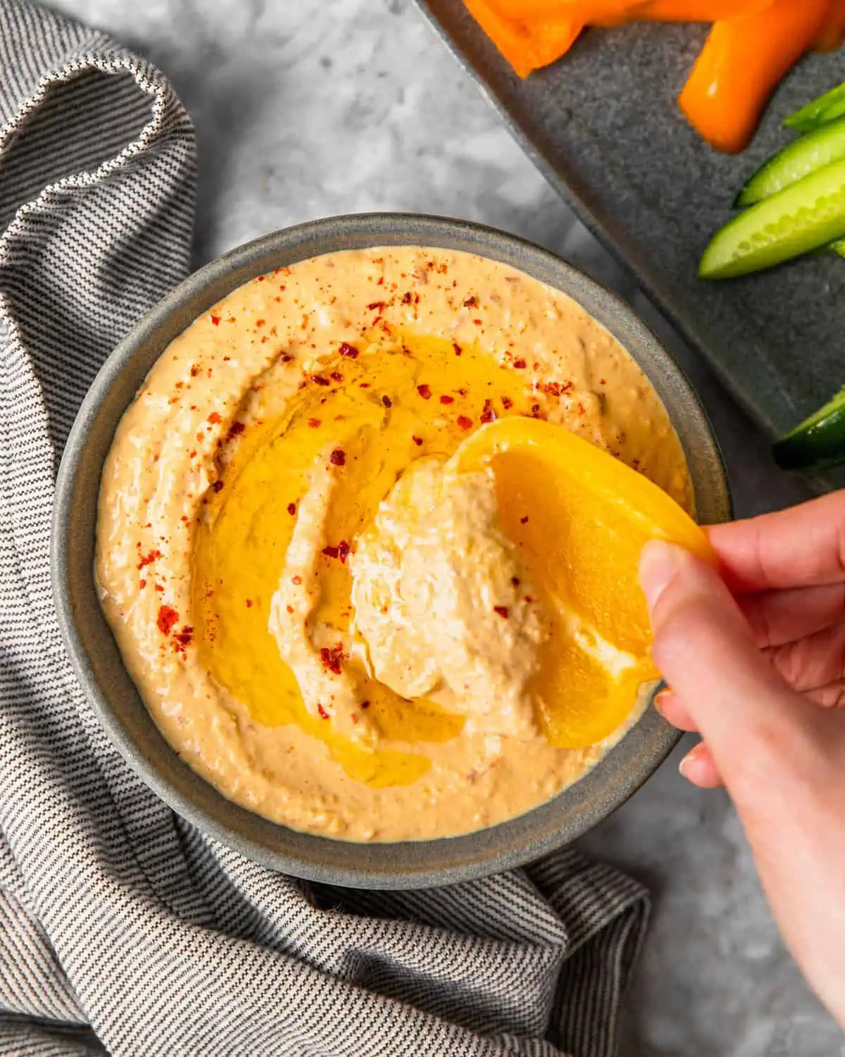 scooping some hummus with a sweet bell pepper. 