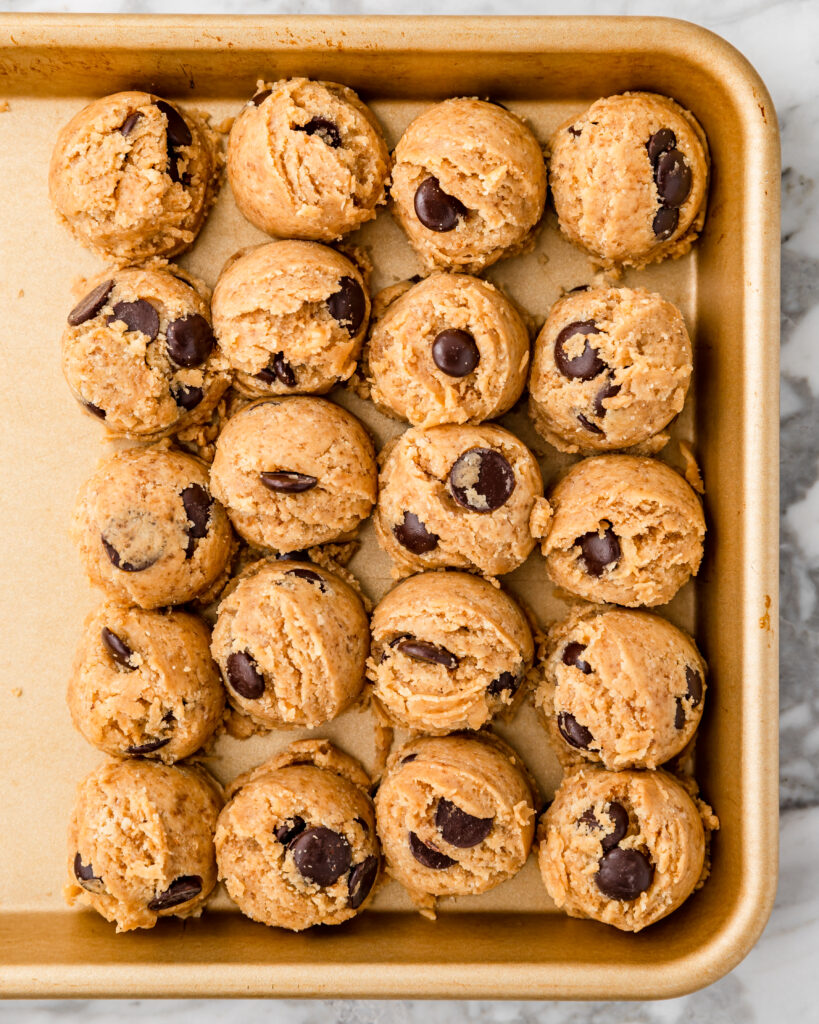 chocolate chip cookie doughs on a baking sheet.