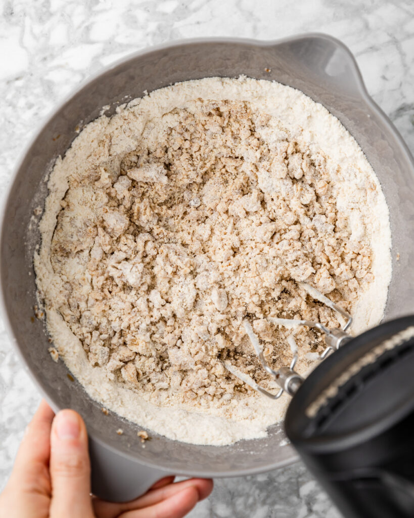 mixing in dry ingredients with the sugar and butter.