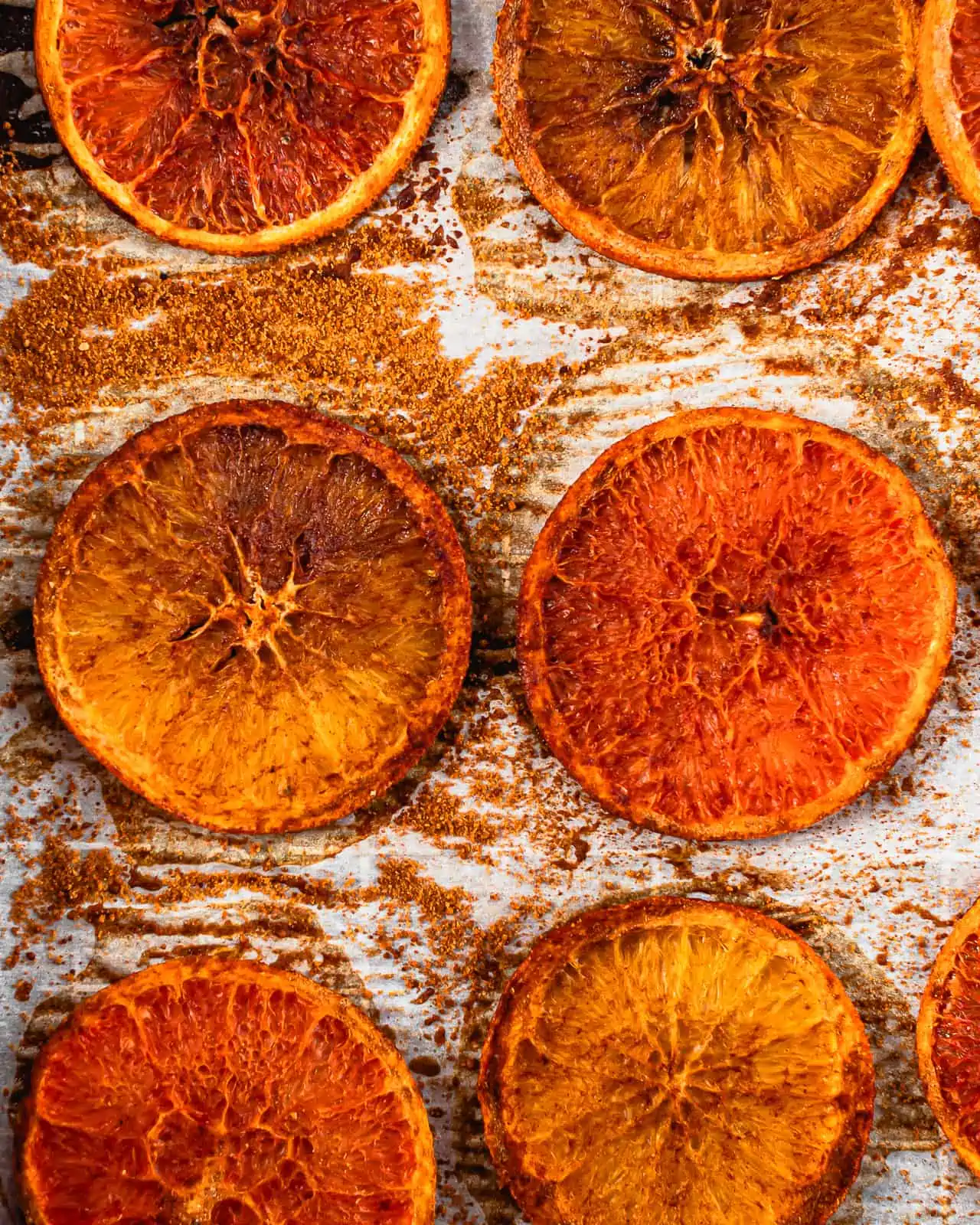 dehydrated orange slices post-baking on a baking sheet.
