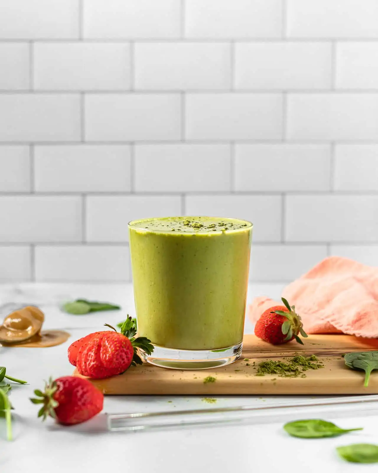 strawberry matcha smoothie in a cup on a board. 