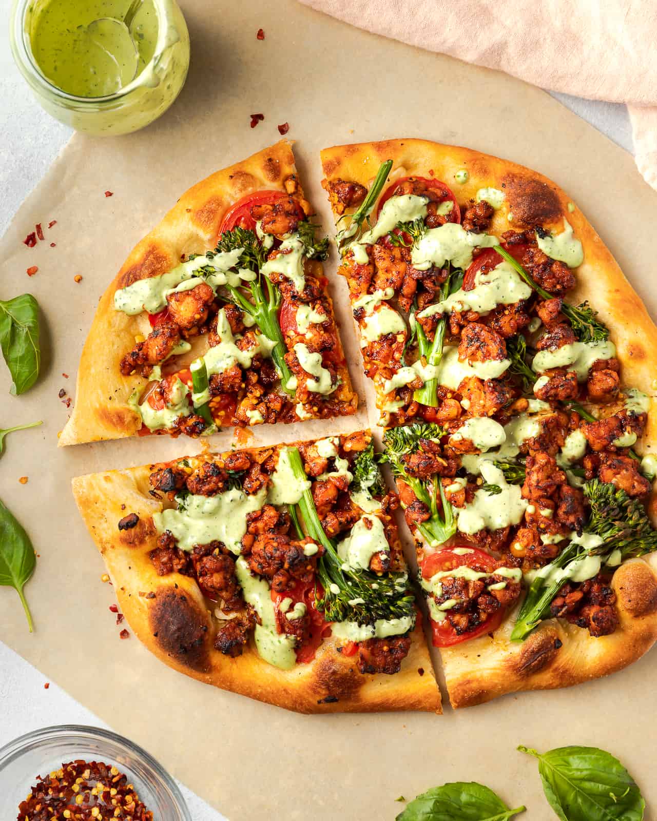 Pizza with broccolini, tempeh, tomatoes and basil sauce