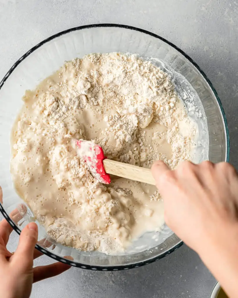 mixing pizza dough ingredients together in a bowl.