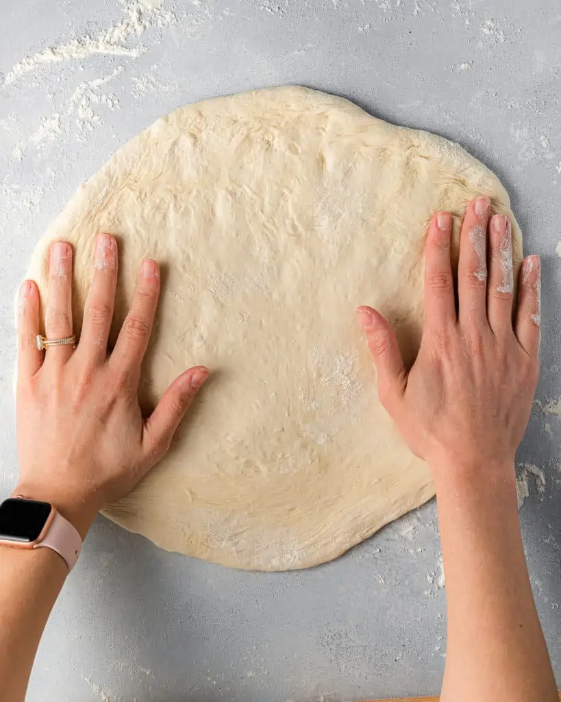 rolling out pizza dough into a 6-inch round pizza.