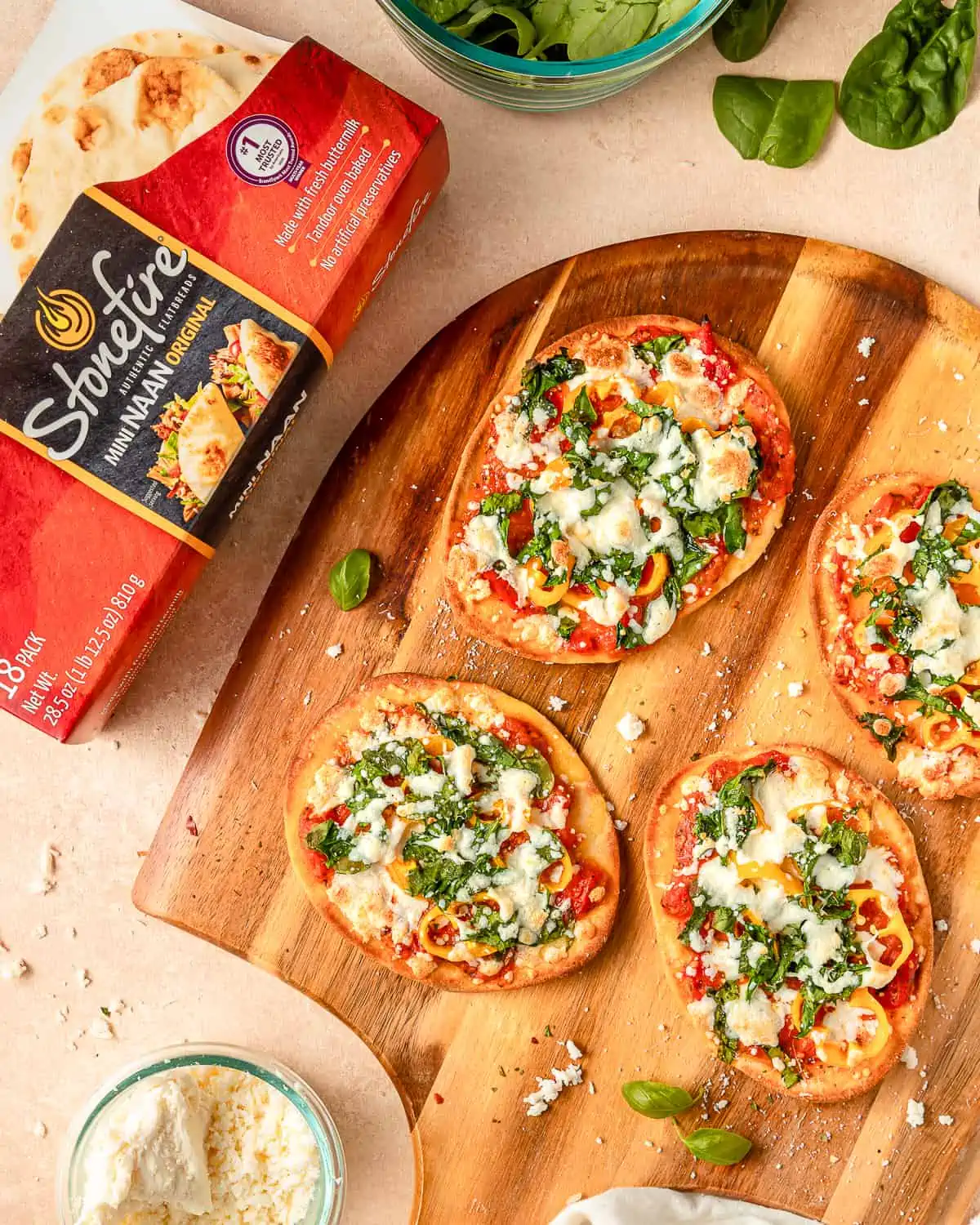 baked mini naan pizzas on a pizza peel.