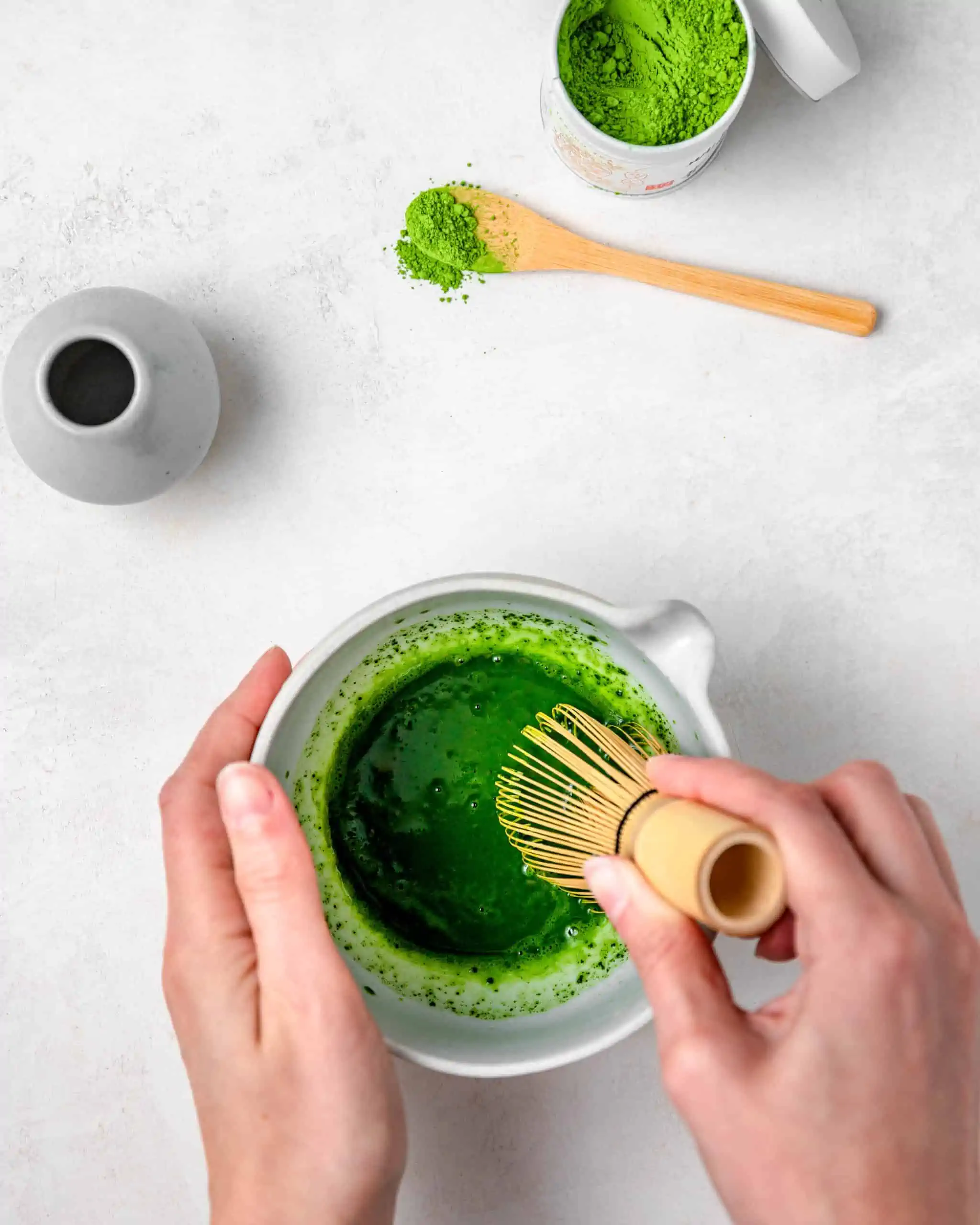 Mixing Matcha with hot water in a bow.