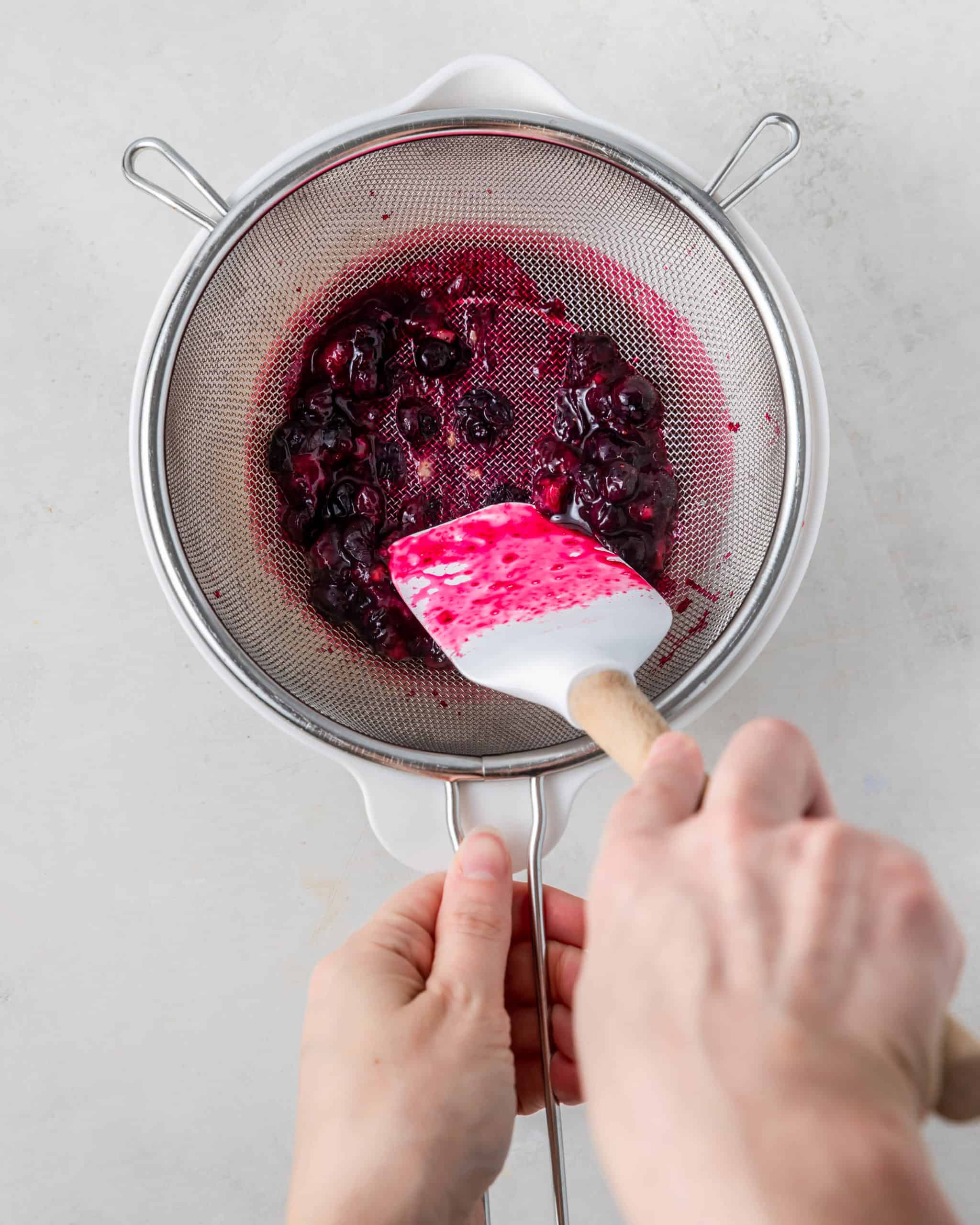 straining blueberry juice from the pulp.
