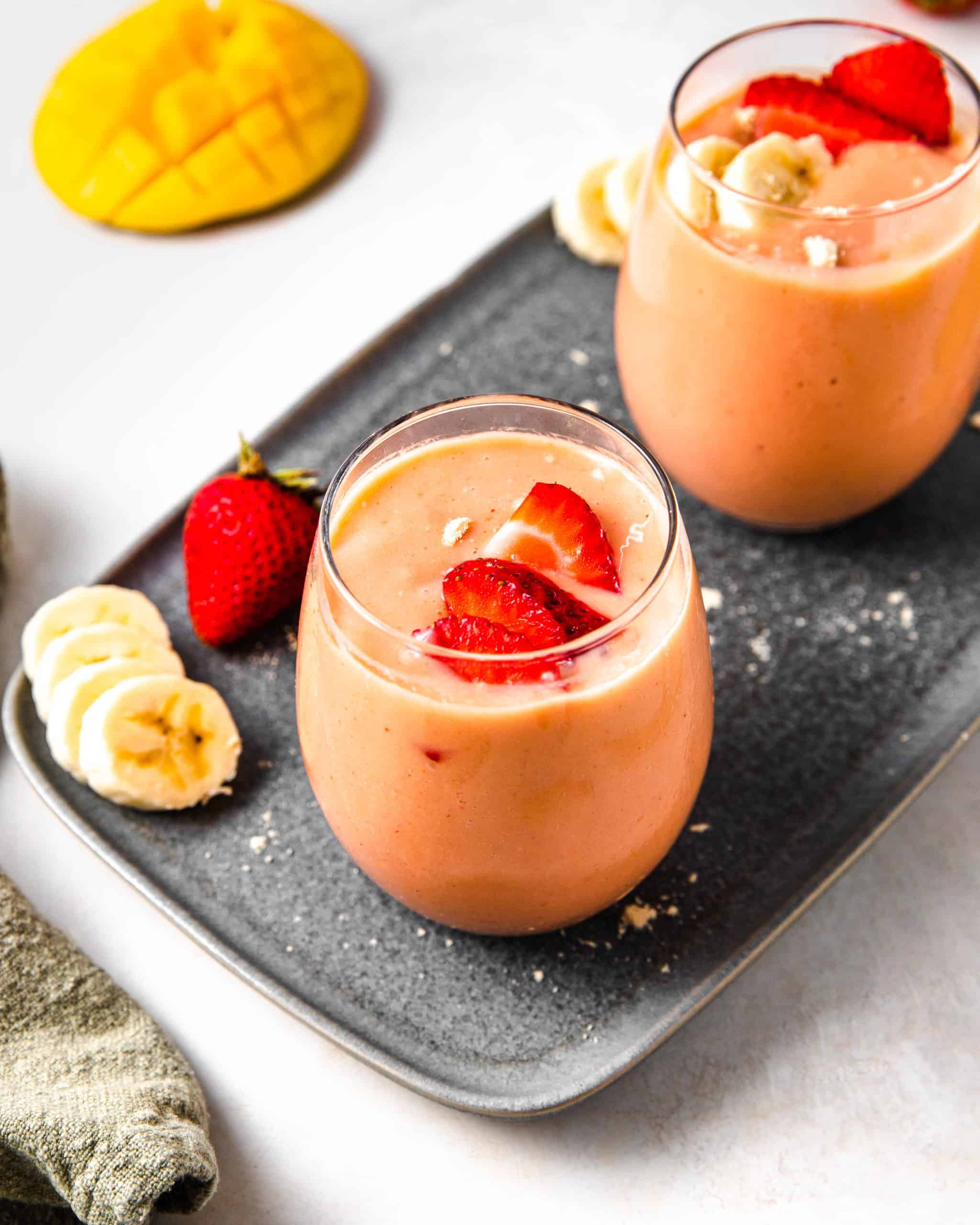 2 glasses of strawberry mango banana smoothie. 