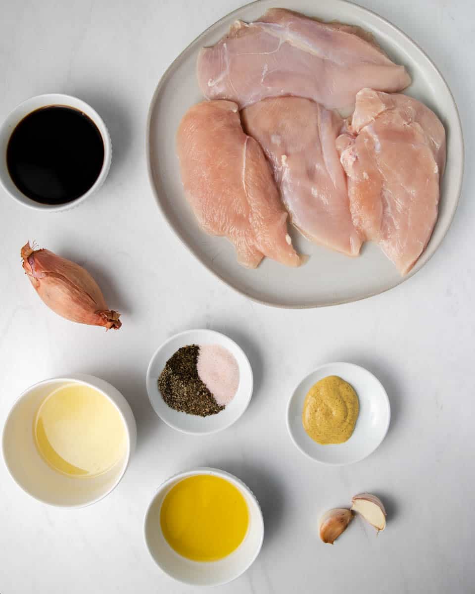 ingredients for balsamic glazed chicken: garlic, shallot, chicken breast, balsamic vinegar, olive oil, lemon juice, dijon mustard, and spices. 