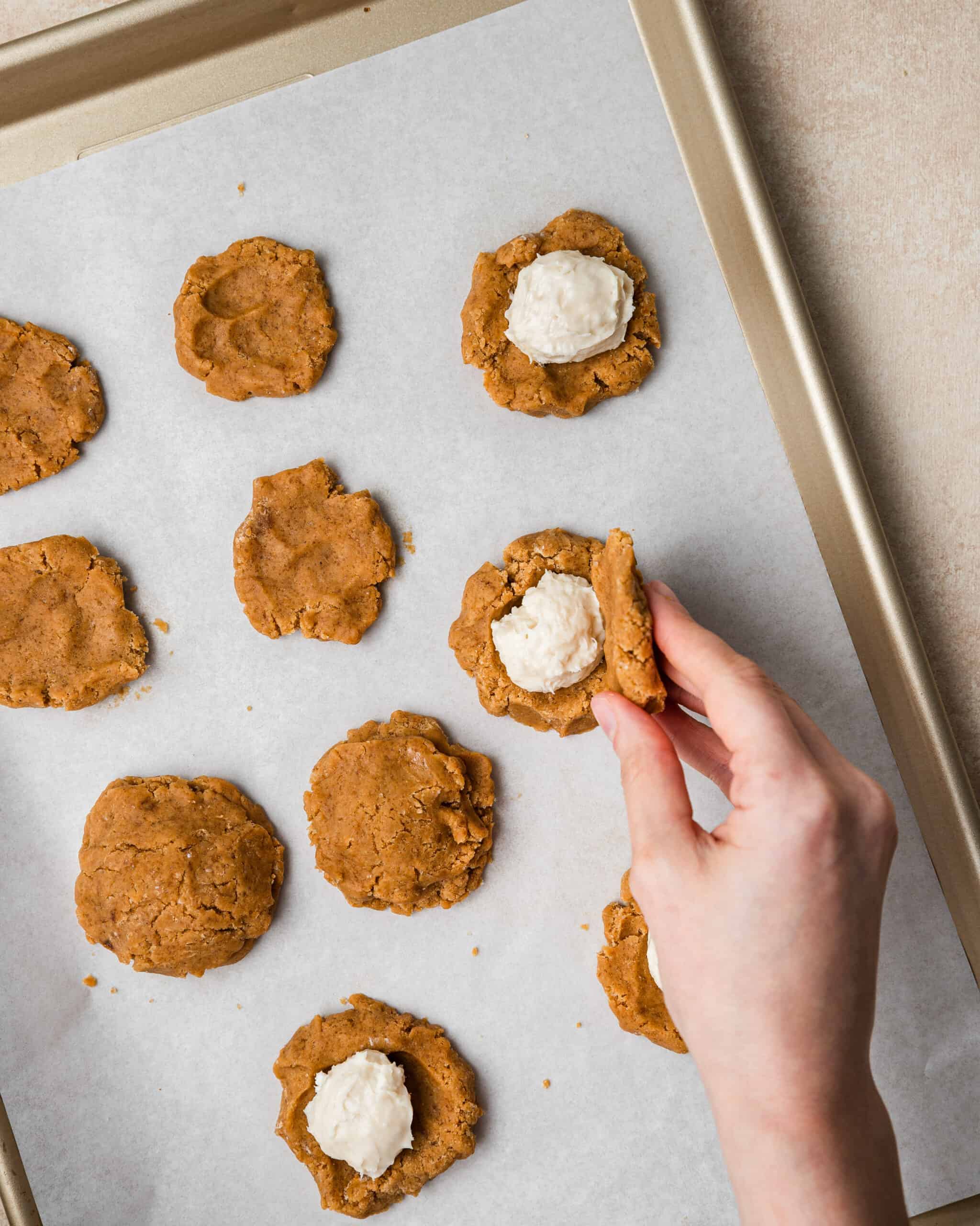 putting cream cheese in pockets of the cookies.