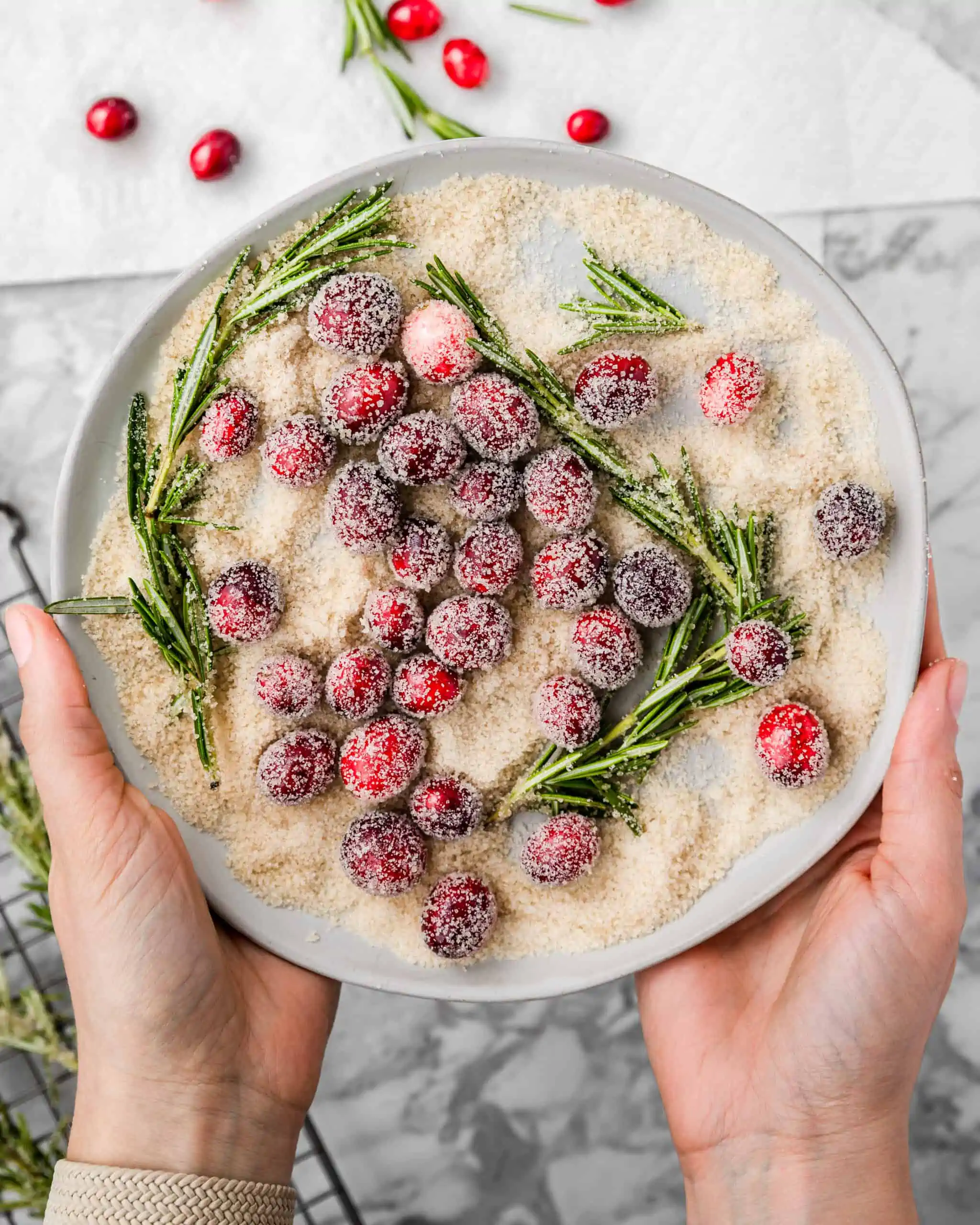 a plate of sugared cranberries and rosemary.