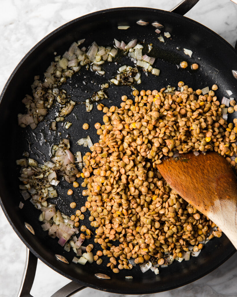 cooking lentils with onion and garlic in a saute pan.