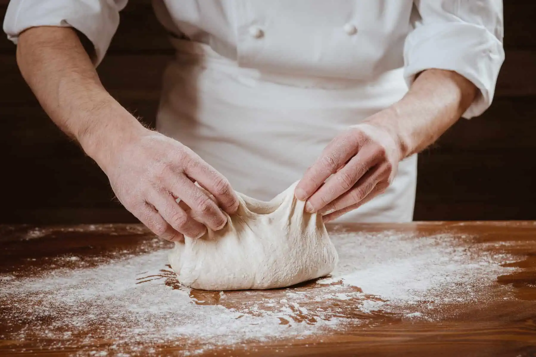 shaping pizza dough on a floured surface. 
