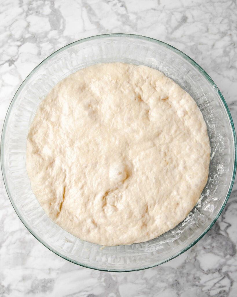 fermented dough inside the bowl that has doubled in sized.