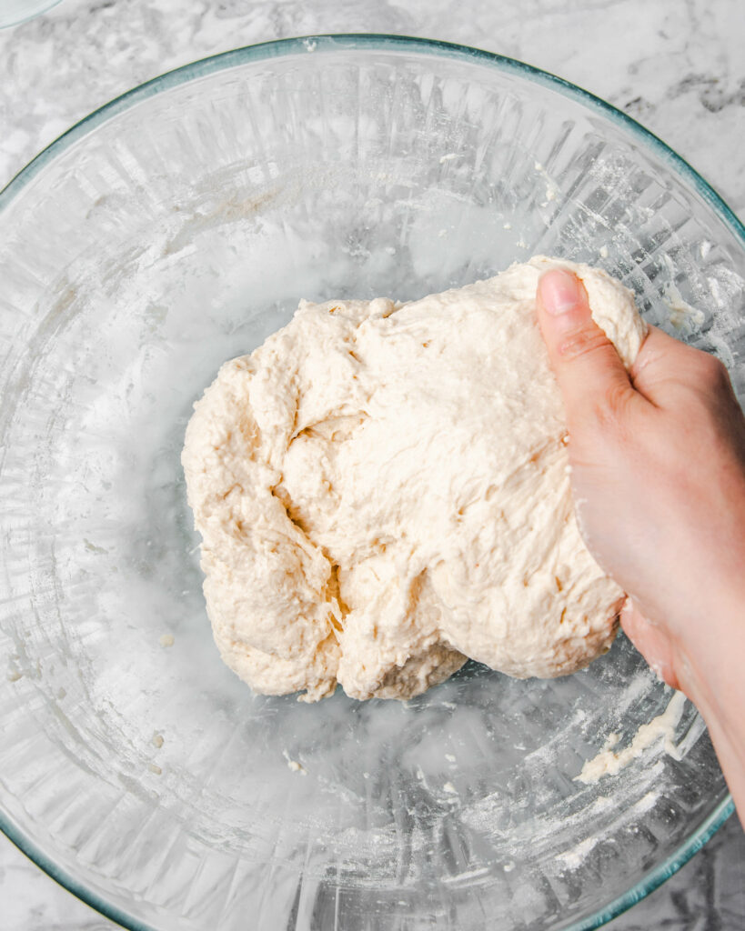 folding the dough by hand in the bowl.