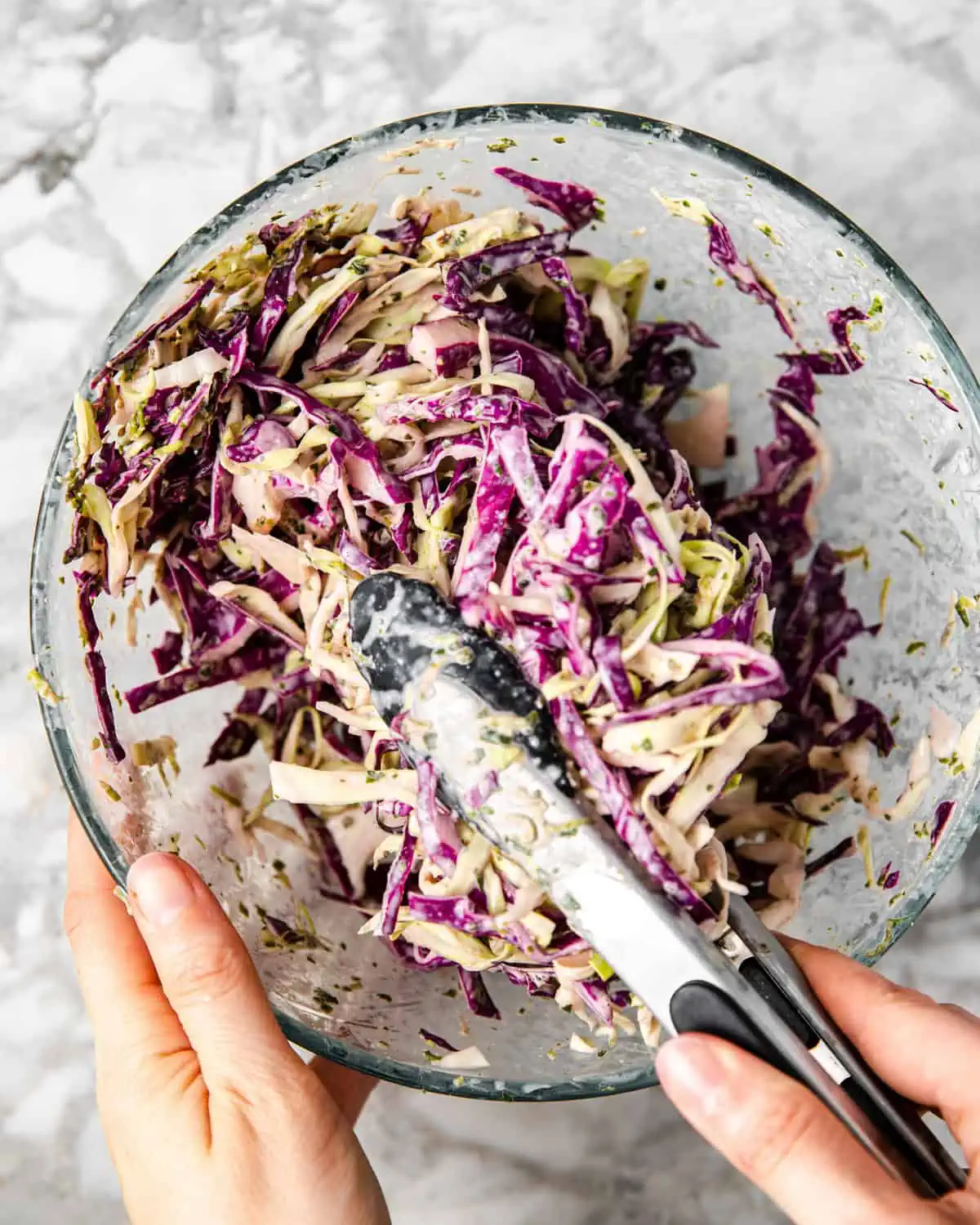 red and green cabbage shredded and mixed with crema in a bowl. 