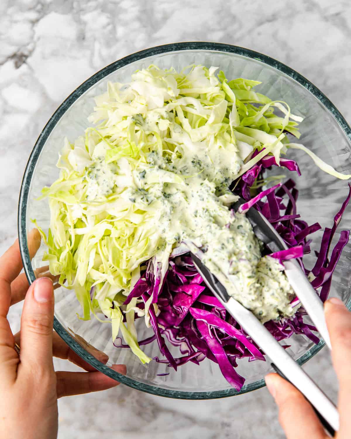 tossing shredded cabbage with cilantro lime sauce.